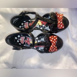 Black sparkly with red and white polka dotted bow. Size 8